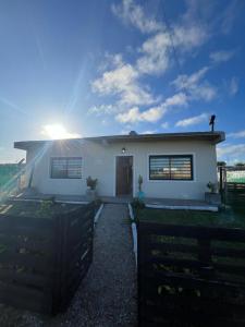 Une petite maison blanche avec le soleil dans le ciel dans l'établissement El Eden2, à Playa Dorada