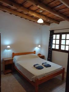 a bedroom with a bed with two blue towels on it at Apart Mirador del lago- Solo para adultos in Las Rabonas
