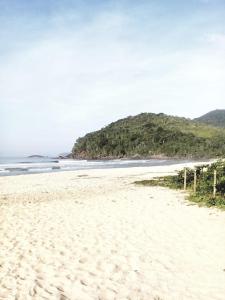 piaszczysta plaża z wyspą w oddali w obiekcie Suite 1 a 80 metros do mar de Itamambuca, Ubatuba w mieście Ubatuba