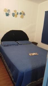 1 dormitorio con 1 cama con edredón azul en Tu lugar de relax! Se reserva solo con seña, en Guazuvirá