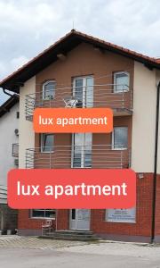 a building with two orange signs in front of it at LUX APARTMENT in Banja Luka