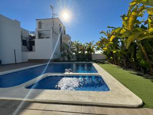 a pool with a water fountain in front of a house at La Zenia Boulevard & Beach House in Orihuela Costa