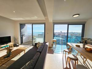 een woonkamer met een bank en een tafel bij Dios Ponte Finikoudes Beachfront Duplex Penthouse in Larnaka