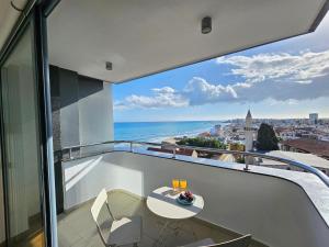 balcón con mesa y vistas al océano en Dios Ponte Finikoudes Beachfront Duplex Penthouse en Lárnaca
