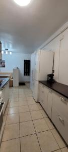 a kitchen with white appliances and a tile floor at Studio BDN in Sîngeorgiu de Mureş