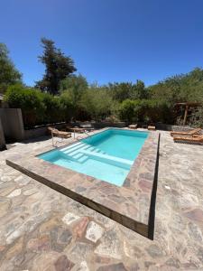 a swimming pool with a table and a chair in a yard at Hotel Corvatsch Chile in San Pedro de Atacama