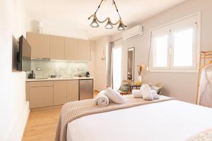 Un dormitorio blanco con una cama y una cocina. en Olympian Goddess Demetra, en Heraclión