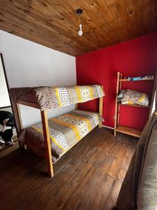two bunk beds in a room with a red wall at Complejo La Rosa Molinari Cosquin in Córdoba