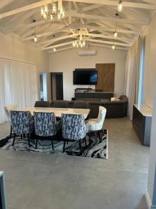 a living room with a table and chairs and a couch at De Marea villa in Naboomspruit