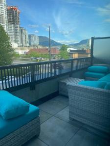 d'un balcon avec des chaises en osier et une vue sur la ville. dans l'établissement Spacious 2-bed, 2-bath condo in downtown Kelowna!, à Kelowna