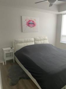 a bedroom with a bed with a black blanket at Spacious 2-bed, 2-bath condo in downtown Kelowna! in Kelowna