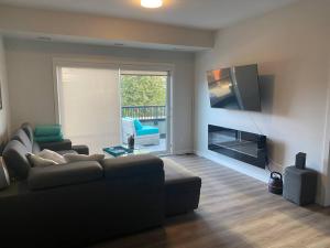 Il comprend un salon doté d'un canapé et d'une télévision à écran plat. dans l'établissement Spacious 2-bed, 2-bath condo in downtown Kelowna!, à Kelowna