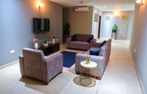 a living room with two couches and a tv at The Pearls - Penthouse in East Legon