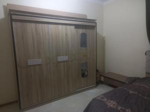 a large wooden door in a bedroom with a bed at Rum Bedouin House in Disah
