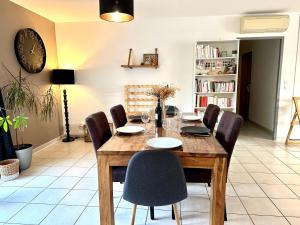 uma sala de jantar com uma mesa de madeira e cadeiras em Agréable villa proche du Château de Carcassonne ! em Cazilhac