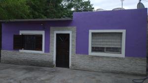 une maison violette avec une porte et deux fenêtres dans l'établissement La casa de valle, à Termas de Río Hondo