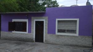 a purple house with a door and two windows at La casa de valle in Termas de Río Hondo