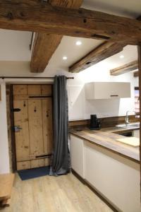 uma cozinha com armários de madeira e uma bancada de cozinha em La p'tite maison em Orschwihr