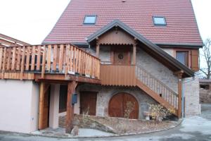 uma casa com um deque em cima em La p'tite maison em Orschwihr