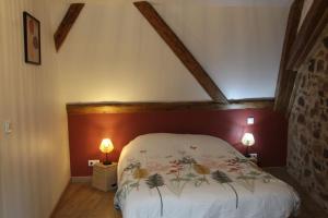 a bedroom with a bed with a floral bedspread at La p'tite maison in Orschwihr