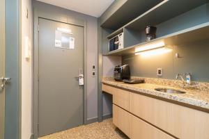 uma pequena cozinha com um lavatório e uma porta em Apartamento em hotel 5 Estrelas Brasília - GMB0414 em Brasília