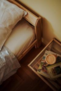 ein kleines Bett mit einem Holzrahmen und einer Zeitschrift in der Unterkunft ΕΥΕΛΗ in Edessa