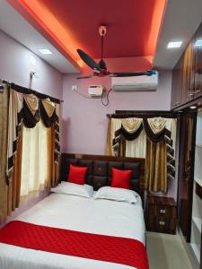 a bedroom with a large bed with red pillows at Alif serviced Apartment for Families and Executives in Tambaram