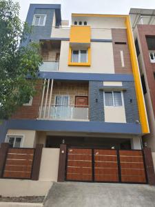 a house with brown doors and a garage at Alif serviced Apartment for Families and Executives in Tambaram