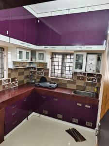 TambaramAlif serviced Apartment for Families and Executives的一个带紫色橱柜和水槽的大厨房