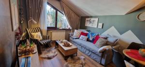 a living room with a couch and a table at PinePino Borovets, aparthotel Borovets Gardens A60 in Borovets