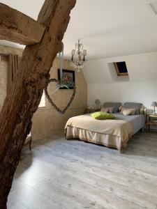 ein Schlafzimmer mit einem großen Bett in einem Zimmer in der Unterkunft Maison au cœur du Perche in Val-au-Perche