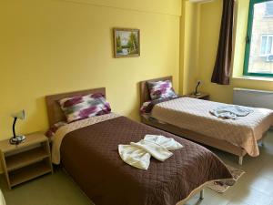 a bedroom with two beds with shoes on the bed at Хотел Тракия in Haskovo +8 photos
