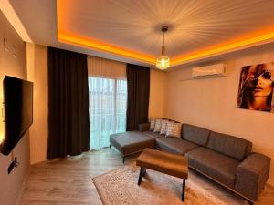 een woonkamer met een bank en een tv bij SAYA LIFE KONAKLAMA in Mersin