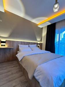 una camera da letto con un grande letto con una grande finestra di SAYA LIFE KONAKLAMA a Mersin