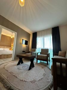 een woonkamer met een tafel en een slaapkamer bij SAYA LIFE KONAKLAMA in Mersin