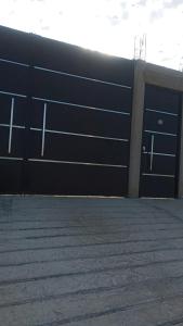 un bâtiment avec deux portes de garage dans un parking dans l'établissement Hospedaje Mamá Coti, à Santa Ana Chiautempan