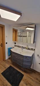 a bathroom with a sink and a large mirror at Appartement Gletscher-Koje in Tux