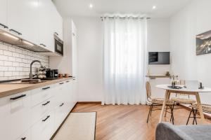 a kitchen with white cabinets and a table at Sweethome Marconi in Rome