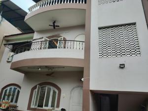 a man sitting on the balcony of a house at Serene Homestay (Mini -For 2 to 3 Guest) in Panaji