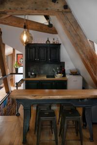 a kitchen with a wooden table and stools at Loft dans le clocher face au chateau in Bonnelles