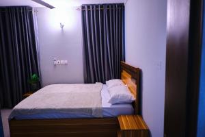 um pequeno quarto com uma cama e cortinas em The Pearls - Penthouse em East Legon