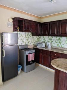 a kitchen with a black stove and a refrigerator at M & L Shared Apartment in Punta Cana +27 photos