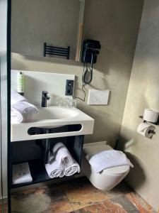 a bathroom with a white sink and a toilet at Hotel Simader in Bad Gastein