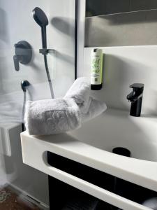 um balcão de casa de banho com um lavatório com toalhas em Hotel Simader em Bad Gastein