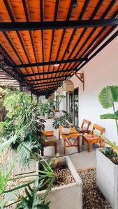 un patio con mesa, sillas y plantas en TỊNH House Phú Quốc en Phu Quoc