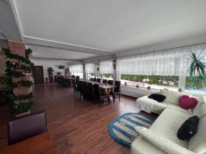 a living room with white couches and a dining room at The Brothers House Bran in Bran