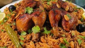 un plato de comida con pollo y arroz en Rum Bedouin House, en Disah