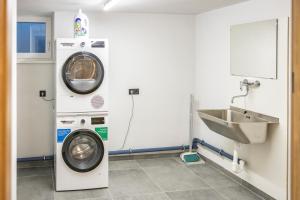 uma casa de banho com uma máquina de lavar roupa e um lavatório em RIVERSIDE RAURIS APARTMENTS em Rauris