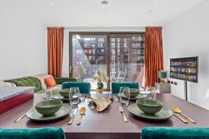 a dining room table with bowls and plates on it at CENTRAL LONDON STAY-Fabulous Ultra-Central London Luxury Designer One Bedroom Flat with inner garden view balcony AC and kitchen in London