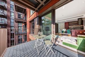 a balcony with a table and chairs on it at CENTRAL LONDON STAY-Fabulous Ultra-Central London Luxury Designer One Bedroom Flat with inner garden view balcony AC and kitchen in London